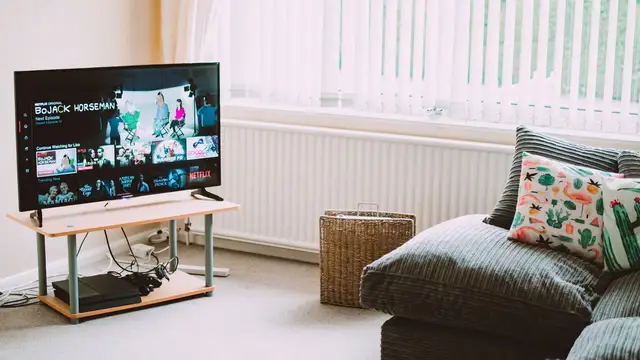 Modern high-definition TV displaying streaming apps beside a tablet