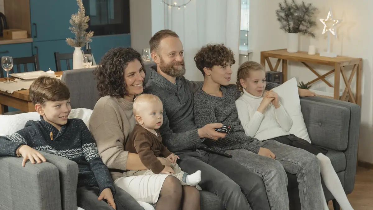 Household enjoying digital entertainment together on a sofa