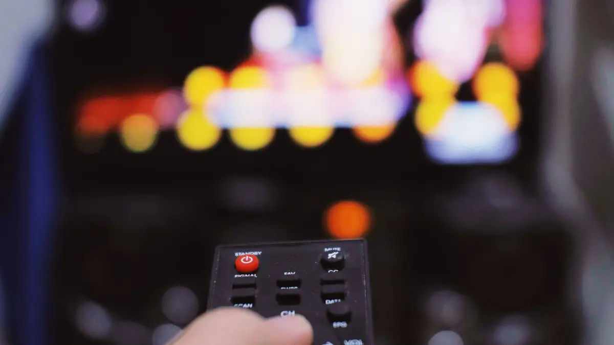 Viewer comparing streaming choices with a television remote