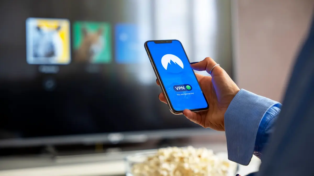 Viewer using a VPN on a phone beside a smart television
