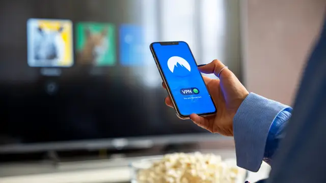 Viewer using a VPN on a phone beside a smart television