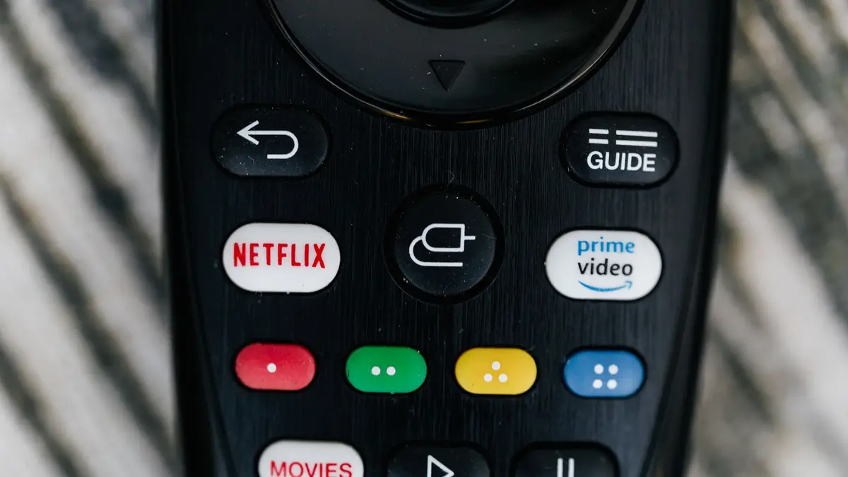 Streaming remote with dedicated app buttons in front of a TV