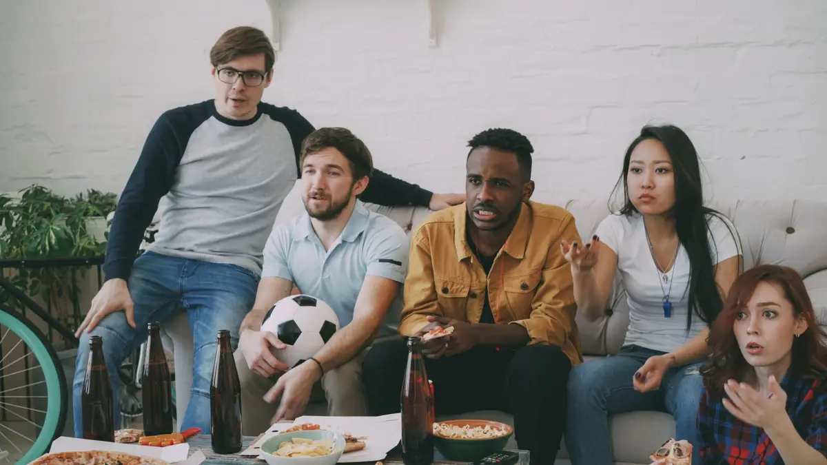 Football supporters watching a match together on television