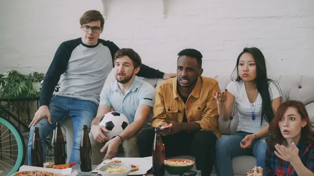 Football supporters watching a match together on television