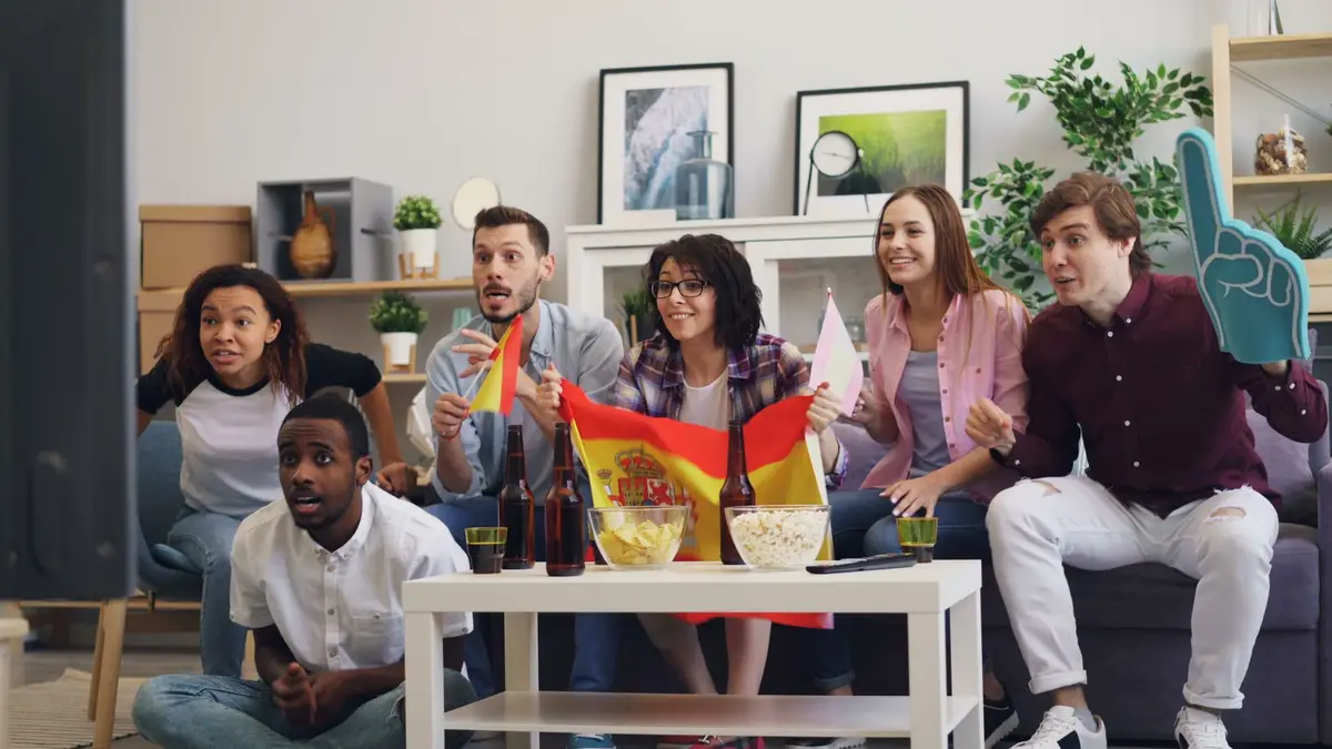 Friends watching a live football match together at home
