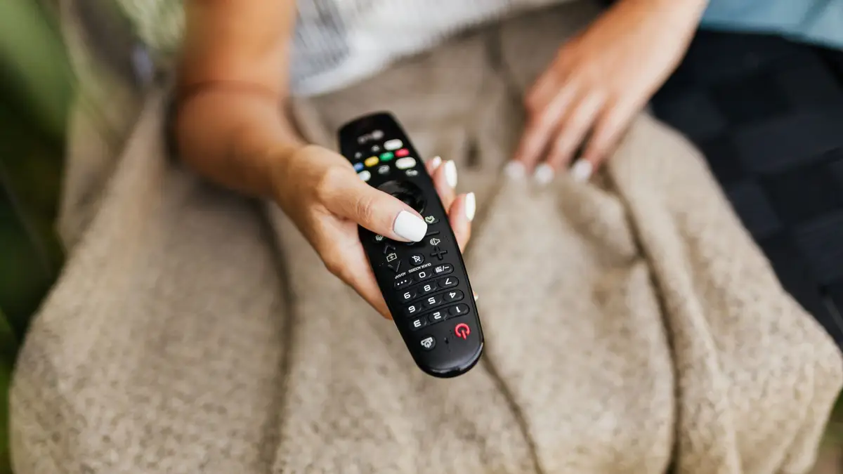 Viewer relaxing at home while choosing television content